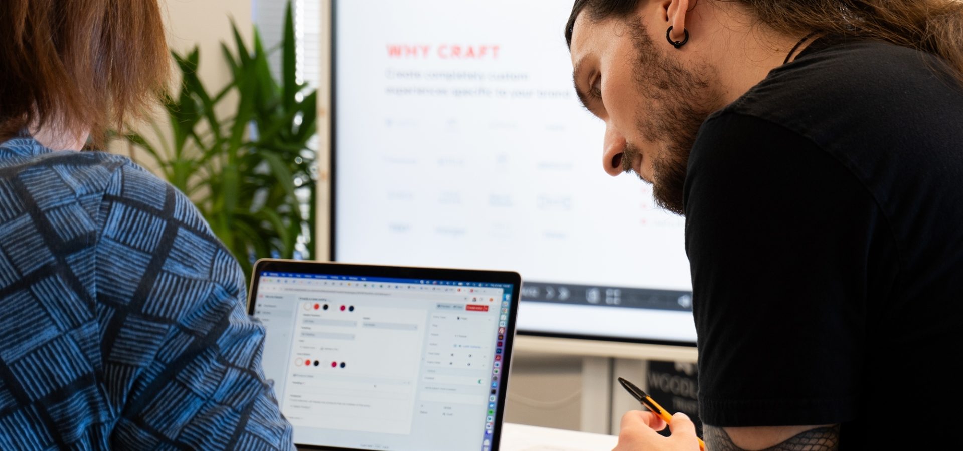 Craft cms developers Judith and Luke reviewing a website design on laptop