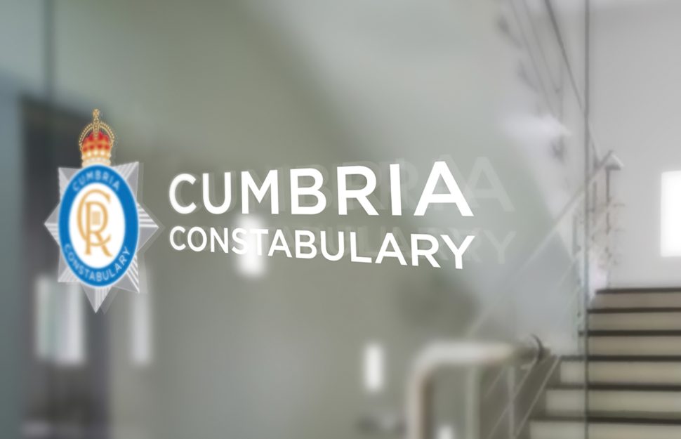 Cumbria Constabulary's new and updated police crest, featuring King Charles lll's cypher on a glass door as a window vinyl in an official building.