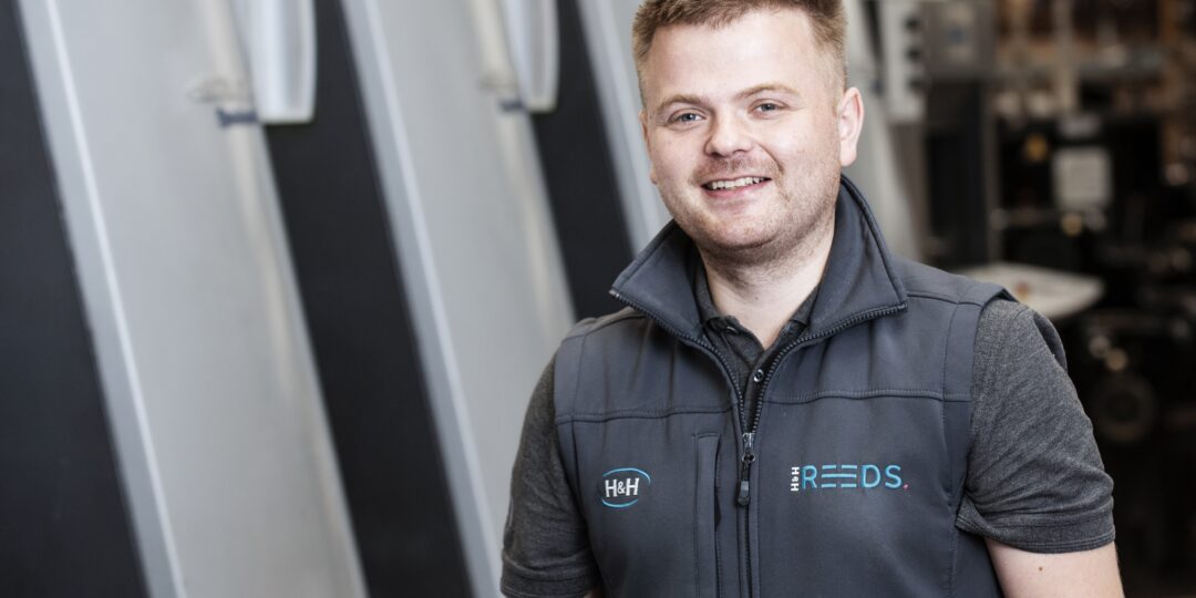Jamie standing in front of the Litho printer in Penrith