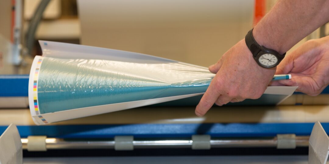 Hand pulling paper from the commercial litho printer in Penrith