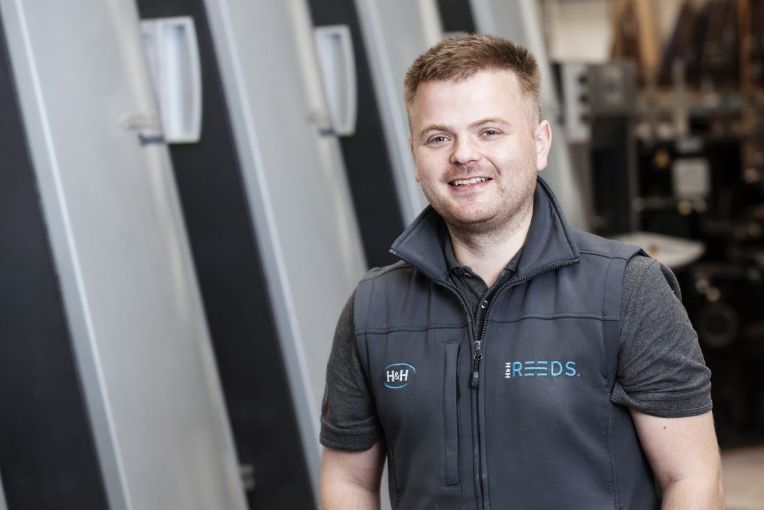 Jamie standing in front of the Litho printer in Penrith