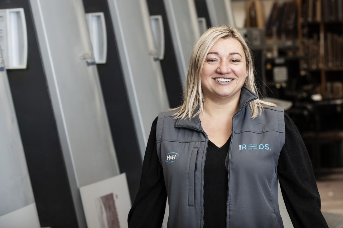 Sasha standing in front of the Litho printer in Penrith