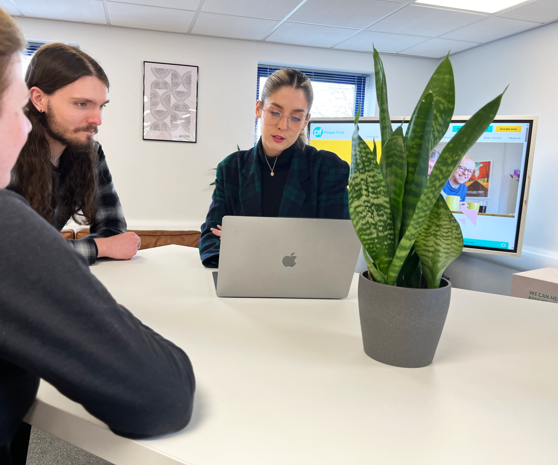 Reeds team reviewing a website design around a table in the Carlisle studio