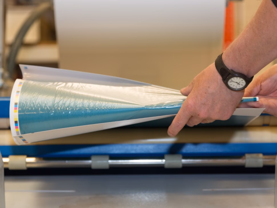Hand pulling paper from the commercial litho printer in Penrith