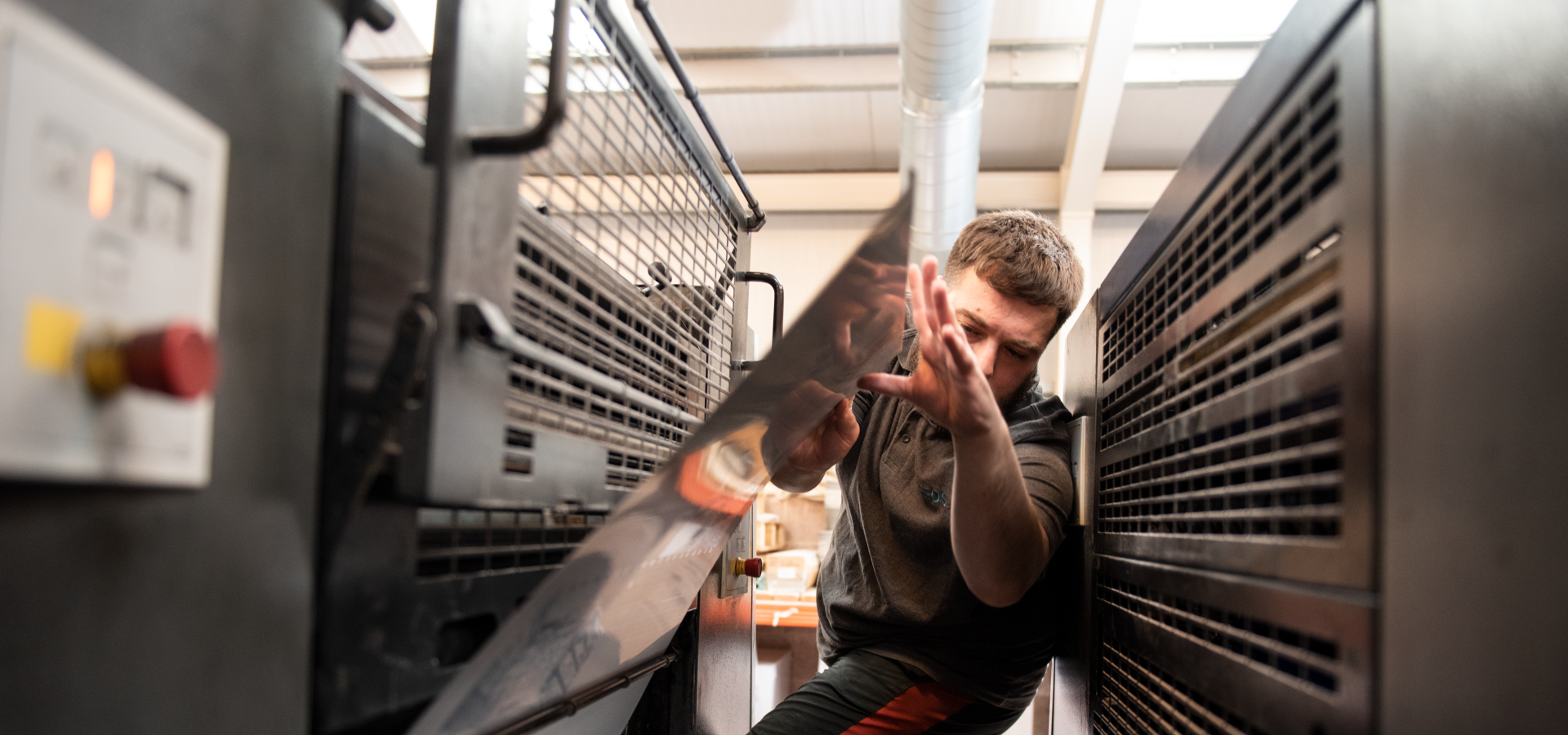 James inserting printing plates into the Heidelberg press at Reeds Printers