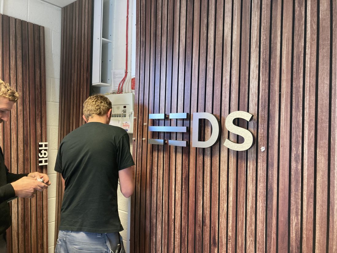 Reeds Penrith signage logo being fitted to the wall